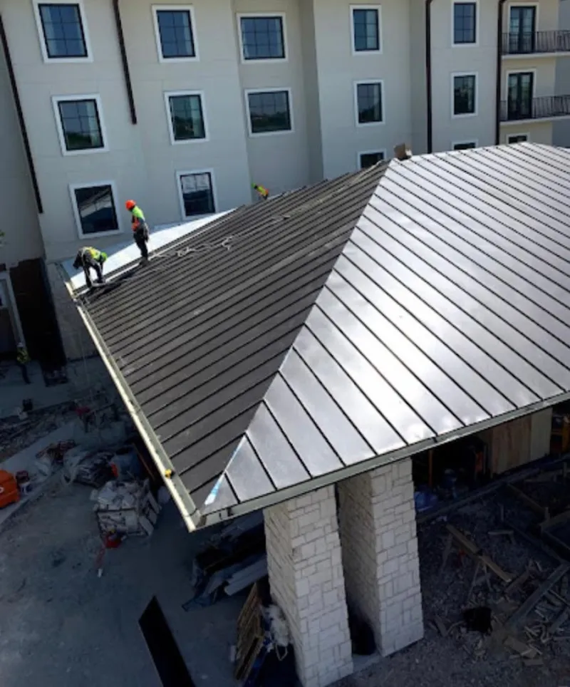 Crew installing standing seam metal roof panels on a commercial project in Rice Lake